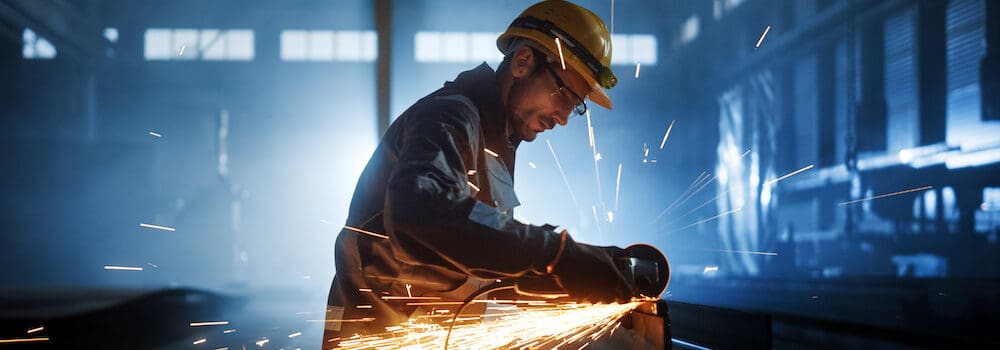 Heavy,Industry,Engineering,Factory,Interior,With,Industrial,Worker,Using,Angle Heavy Industry Engineering Factory Interior with Industrial Worker Using Angle Grinder and Cutting a Metal Tube. Contractor in Safety Uniform and Hard Hat Manufacturing Metal Structures.